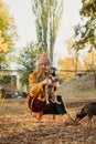 Pet Love. Volunteer woman plays with homeless puppies in the autumn park. Authentic moments of joy girl playing with