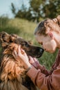 Pet Love. Young pretty happy woman plays with German Shepherd dog. Authentic moments of joy girl playing with her dogs. Pet love, Royalty Free Stock Photo