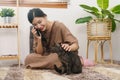 Pet lover concept, Young Asian woman sit on the floor to talking on phone and stroking fur of cat