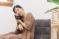 Pet lover concept, Young Asian woman sitting to relax on sofa on floor to playing and hugging cat