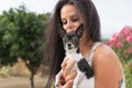 Pet owner caring her small canis familiaris and the canine alert looking to camera. Small old chihuahua attentive in the street