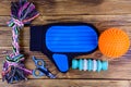 Pet slicker brushes, claw clipper and toys on a wooden background. Top view