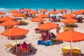 PETANI beach, Greece - July 21, 2020: People relaxing, yellow sunbeds, orange umbrellas, white sand, azure water.