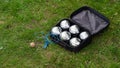 Petanque set with six metal balls in a black case on green grass. Royalty Free Stock Photo