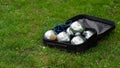 Petanque set with six metal balls in a black case on green grass. Royalty Free Stock Photo