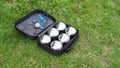 Petanque set with six metal balls in a black case on green grass. Royalty Free Stock Photo