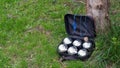 Petanque set with six metal balls in a black case on green grass. Royalty Free Stock Photo