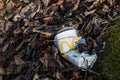 Empty disgarded MacDonalds Drink cup with platic lid lying as litter
