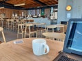 Empty hot drink mug inside empty Starbucks cafe coffe shop with laptop on table for