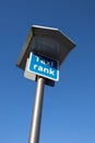 Taxi Rank sign on a tall metal pole with blue sky behind