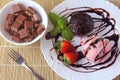 Petit gateau with ice cream on white plate with strawberry over rustic wooden table