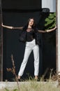 Petite young woman with very long hair wear heels and white pants