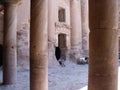 Tourists sitting by a tomb door in Petra Mountain, Jordan