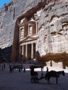 Vertical view of a cart and tourists next to the Treasury in Petra, Jordan