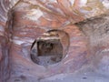 Window of a tomb carved into the reddish rock of the mountain of Petra, Jordan