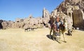 Bbedouin camels and tourists pov near the treasury Al Khazneh carved into the rock at Petra, Jordan