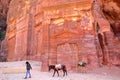 PETRA, JORDAN - MARCH 7, 2016: Colorful tombs in the Outer Siq with a local Bedouin leading his donkeys Royalty Free Stock Photo