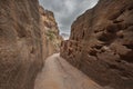 Petra Jordan, Narrow tunnel with a path carved into red rocks in the dry mountain Royalty Free Stock Photo