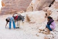 Petra / Jordan - September 2019: An oriental girl watches how the boys solve the donkey problem. Concept of separation of sexes.
