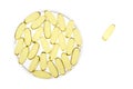 Petri dish of gold gel capsules with one apart