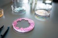 Petri dish with pink glitter sample mixed in analysis fluid in pharmaceutical research lab. Royalty Free Stock Photo