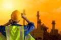 Petrochemical industry engineer looking back view at large petroleum industry factory sunset sky view Royalty Free Stock Photo