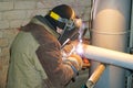 A welder welds technological pipelines with manual arc welding for an oil refinery in Russia. Welded joint