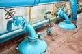 Petrochemical plant interior. Two blue valves with brown red steering wheels over background of pipes buffer reactors Royalty Free Stock Photo