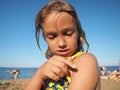 Petrozavodsk, Russia, July 10, 2021. A girl on a sandy beach. A ladybug beetle crawls on the child& x27;s hand. The girl Royalty Free Stock Photo