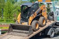 Skid steer loader on a tow truck. tow truck with sliding platform Royalty Free Stock Photo