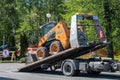 Skid steer loader on a tow truck. tow truck with sliding platform Royalty Free Stock Photo