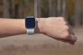 Modern smart watch on the girlÃ¢â¬â¢s hand on the background of the forest