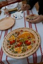 Petrykivka painting style wooden plate, Ukrainian folk art, man`s hands handpainting on a plate, ethnographic master class Royalty Free Stock Photo