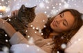 Happy young woman with cat lying in bed at home Royalty Free Stock Photo