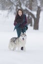 Pets Concepts and Ideas. Happy and Smiling Caucasian Brunette Woman Playing with Husky Dog Outdoors in Park Royalty Free Stock Photo
