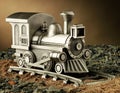 A Product Studio Shot of a Model Steam Engine Train with Track: The train is made of pewter and is also a coin bank.