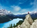 Peyto Lake, Banff National park in Canada with the Canadian Rockies in the distance, and a woman sat on a rock in the foreground Royalty Free Stock Photo