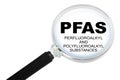 PFAS CONCEPT WITH MAGNIFYING GLASS ISOLATED ON WHITE FOR EASY SELECTION Royalty Free Stock Photo