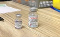 A pfizer and a Moderna vial Covid-19 vials vacines at a pharmacy. Concept: Second booster