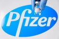 Pfizer vaccine in the bottle in doctors hand in rubber gloves on the background of logo, January 2021, San Francisco