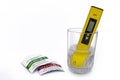 PH meter measuring the pH of the water in the glass on isolated white background. used solution solution packages Royalty Free Stock Photo