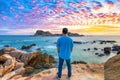 Silhouette traveler man watching a small island relaxing at sunset