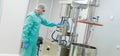 Pharmaceutical factory man worker in protective clothing working with control panel in sterile working conditions Royalty Free Stock Photo