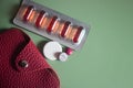 Pharmaceutical pills and medicine with brown leather wallet on mint background