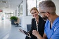 Pharmaceutical sales representative talking with doctor in medical building. Ambitious female sales representative