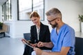 Pharmaceutical sales representative talking with doctor in medical building. Ambitious female sales representative Royalty Free Stock Photo