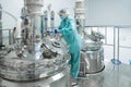 Pharmaceutical factory woman worker in protective clothing operating production line in sterile environment Royalty Free Stock Photo