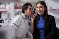 Pharmaceutical worker checking young asian woman ear for infection