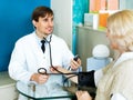 Pharmaceutist taking mature patients blood pressure using sphy Royalty Free Stock Photo