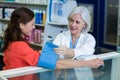 Pharmacist checking blood pressure of customer